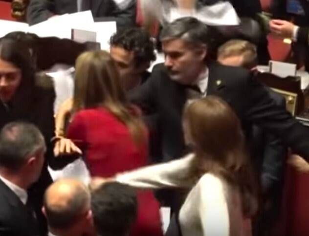 Il fotogramma in cui la senatrice Bottici (vestita in bianco) allontana dai banchi del governo la Malpezzi (vestita in rosso)