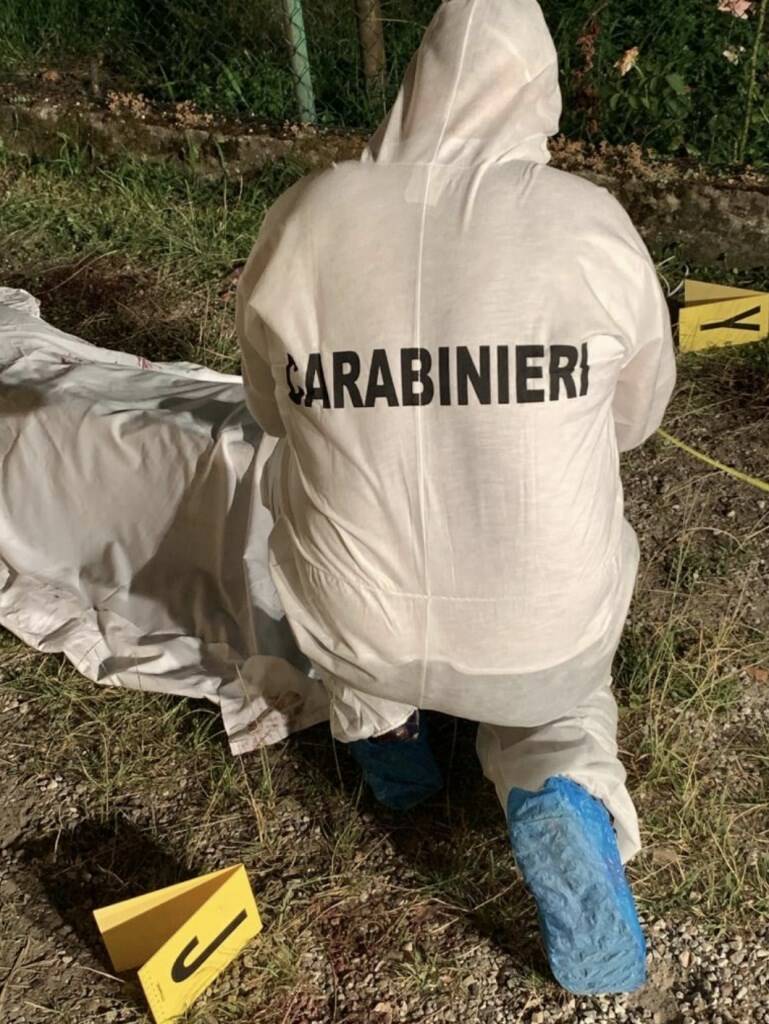 Un carabiniere nel corso dei rilievi vicino al cadavere coperto con un telo