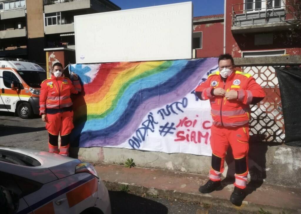 Lo striscione e i volontari della Pubblica Assistenza di Marina di Carrara